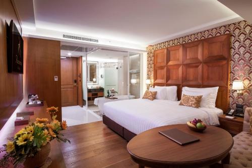 a bedroom with a bed and a table in a room at Amaranta Hotel in Bangkok