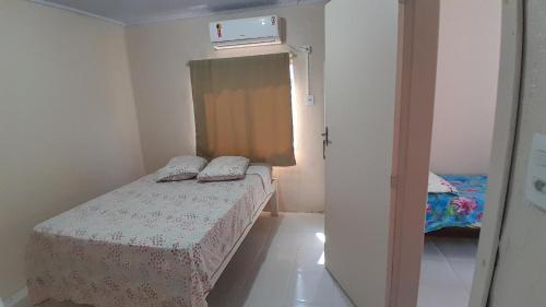 a small bedroom with a bed and a window at Quartos em Ametista do Sul in Ametista do Sul