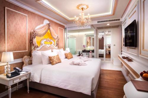 um quarto com uma grande cama branca e um lustre em Amaranta Hotel - SHA Plus em Bangkok