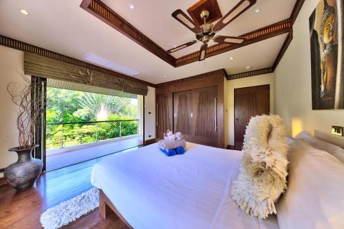 a bedroom with a large bed and a large window at Villa Seven Swifts - Bangrak Ocean View in Bophut 