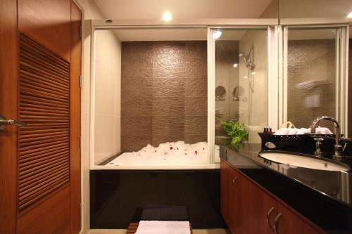 a bathroom with a tub and a sink and a shower at Amaranta Hotel in Bangkok