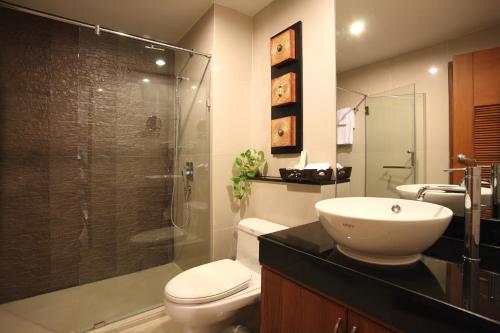 a bathroom with a shower and a toilet and a sink at Amaranta Hotel in Bangkok