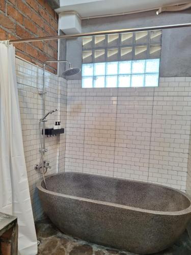 a large bath tub in a bathroom with a window at InN House Homestay in Dadapan