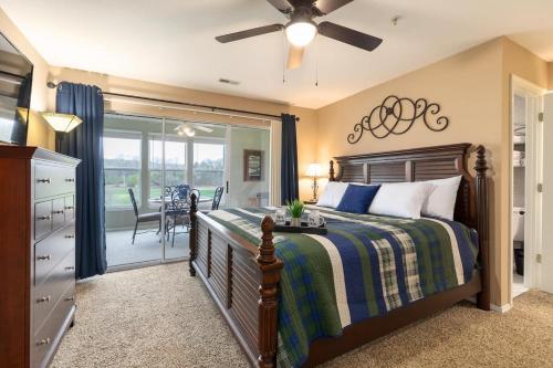a bedroom with a bed and a sliding glass door at Little House on the 12th Hole - Luxury Golf Condo in Branson