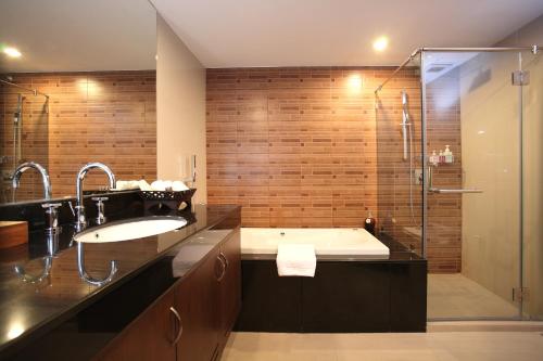 a bathroom with a tub and a sink and a shower at Amaranta Hotel in Bangkok