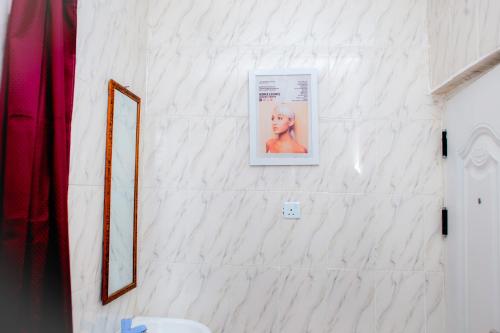 a bathroom with a poster on a white wall at UNIA Homes in Benin City