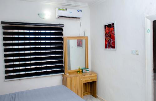 a bedroom with a window with a mirror and a bed at UNIA Homes in Benin City