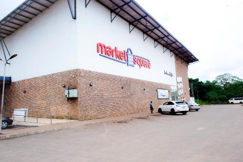a man standing in front of a brick building at UNIA Homes in Benin City
