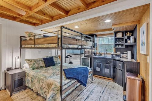 a bedroom with a bunk bed and a kitchen at Bare Feet Bunkhouse-Close to beach & dog friendly in Gulfport