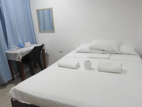 a bedroom with two beds and a desk and a mirror at Pacifico Seaside Lodge in Moalboal