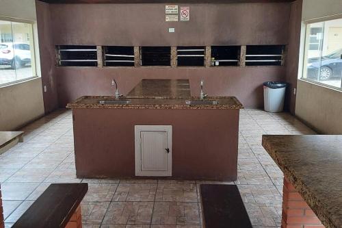 a kitchen with two sinks in a room with windows at Apartamento amplo na Beira Mar de Tramandaí-RS in Tramandaí