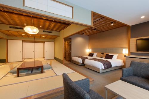a bedroom with a bed and a living room at Miyajima Grand Hotel Arimoto in Miyajima