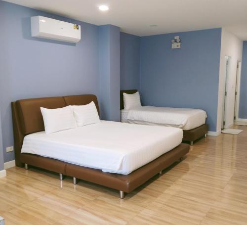 two beds in a room with blue walls at J-Boutique Hotel เจ-บูทีค โฮเทล in Khon Kaen