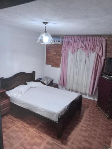 a bedroom with a large bed and a window at Apto CUEVA DEL OSO PARAMILLO 2 Hab 4 Pax in San Cristóbal