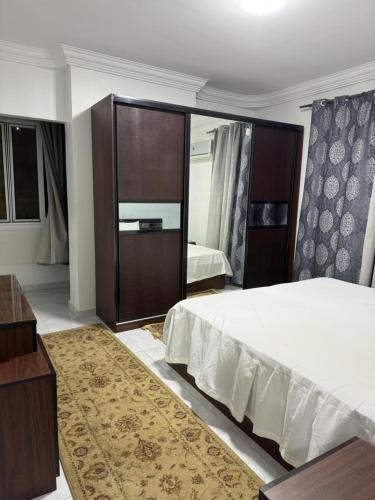 a bedroom with a bed and a large mirror at شقة على كورنيش النيل المعادي Maadi Nile view Cairo in Al Ma‘şarah