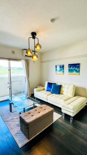 a living room with two couches and a glass table at ocean terrace SESOKO 301 in Ufugumui
