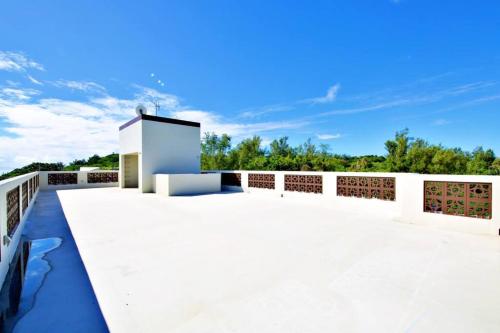 a large patio with white walls and a fence at ocean terrace SESOKO 301 in Ufugumui
