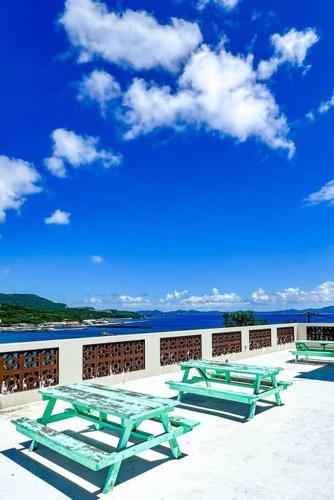 three picnic tables on a patio with the ocean in the background at ocean terrace SESOKO 301 in Ufugumui