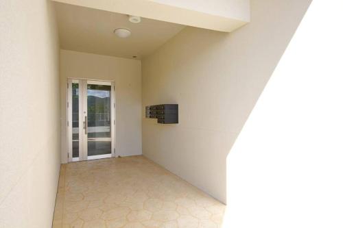 an empty room with a television on a wall at ocean terrace SESOKO 301 in Ufugumui