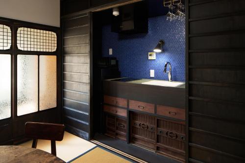 une salle de bain avec un lavabo et un miroir dans l'établissement Tsuyukusa-an, à Kyoto