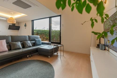 a living room with a couch and a large window at In Aewol Forest 102 in Jeju