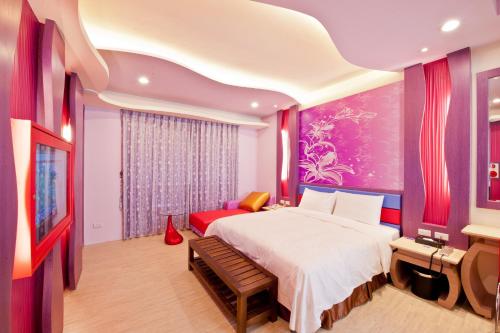 una camera da letto con un letto grande e un divano rosso di Yudali Motel a Donggang