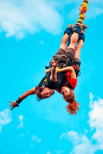 two people are hanging upside down in the sky at Traveler Hostel in San Gil