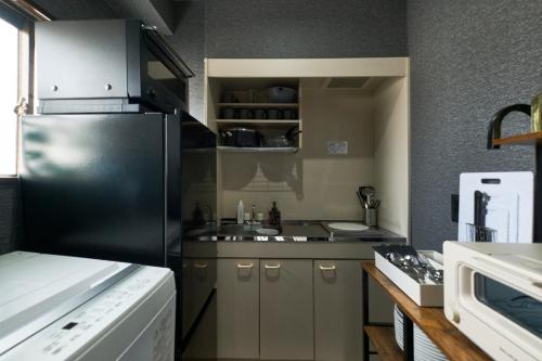 a kitchen with a black refrigerator and a sink at Historic Town in the Heart of Tokyo - Easy Access to Attractions in Tokyo