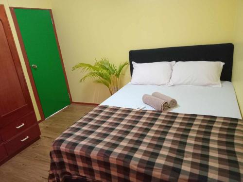 a bedroom with a bed with a checkered blanket at Dream Paradise Apartment in Korotogo