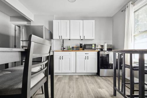 a kitchen with white cabinets and a table at Spacious 4BR 2BA Minutes from the Falls & Casino in Niagara Falls