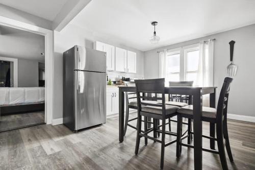 a kitchen with a table and chairs and a refrigerator at Spacious 4BR 2BA Minutes from the Falls & Casino in Niagara Falls