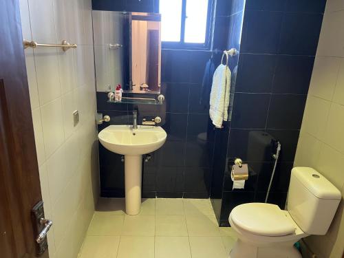 a small bathroom with a toilet and a sink at Three-bedroom Urban Retreat with Terrace AQZ Apartments in Humak