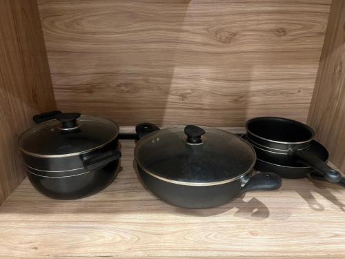 two pots and pans sitting on a wooden table at Three-bedroom Urban Retreat with Terrace AQZ Apartments in Humak