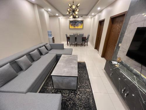 a living room with a couch and a table at Three-bedroom Urban Retreat with Terrace AQZ Apartments in Humak