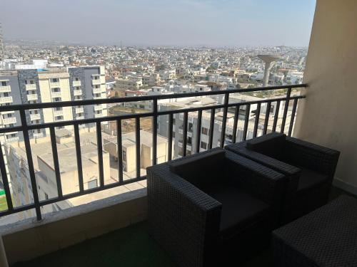 a balcony with two chairs and a view of a city at Three-bedroom Urban Retreat with Terrace AQZ Apartments in Humak