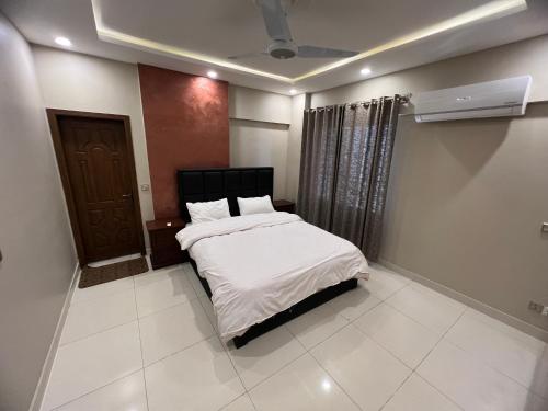 a bedroom with a bed with white sheets and a window at Three-bedroom Urban Retreat with Terrace AQZ Apartments in Humak