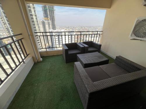 a balcony with a couch and chairs and a view of a city at Three-bedroom Urban Retreat with Terrace AQZ Apartments in Humak
