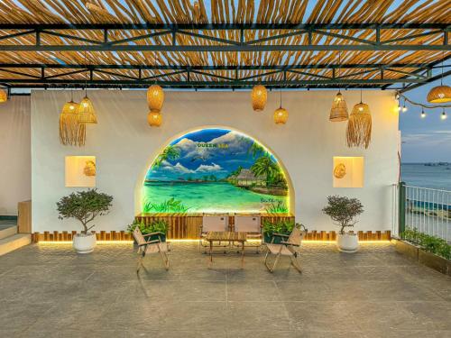 a room with a table and chairs and a painting on the wall at Queen Sea Resort - Đảo Phú Quý in Cu Lao Thu