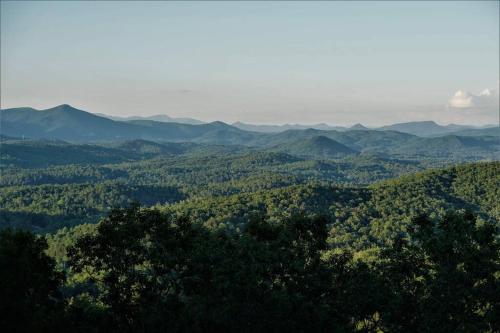 a view of a forest with mountains in the background at Ultimate Log Cabin Experience with BREATHTAKING Views in Yonah