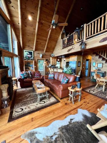 a living room with a couch and a staircase at Ultimate Log Cabin Experience with BREATHTAKING Views in Yonah