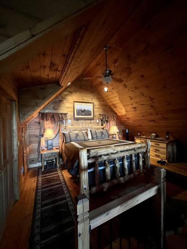 a bedroom with a bed in a wooden cabin at Ultimate Log Cabin Experience with BREATHTAKING Views in Yonah