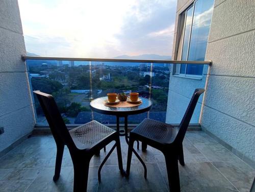 a table and two chairs on a balcony with a view at Moderno y central apartamento in Vallecito