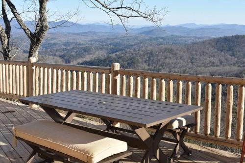 a picnic table and a bench on a deck with a view at Ultimate Log Cabin Experience with BREATHTAKING Views in Yonah