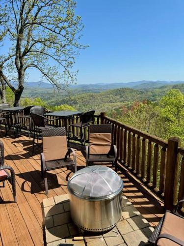 a table and chairs on a deck with a view at Ultimate Log Cabin Experience with BREATHTAKING Views in Yonah