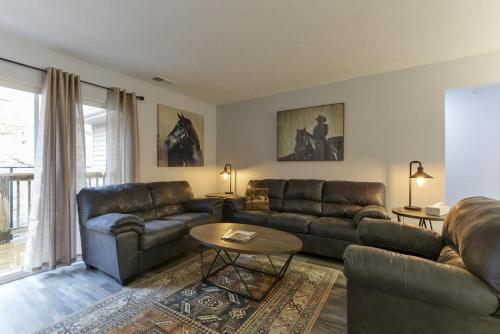 a living room with leather couches and a table at Western Comfort in Branson