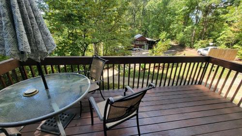 Elk Ridge - cherokee casino GSMNP في Whittier: طاولة زجاجية وكراسي على سطح خشبي