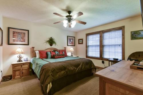 a bedroom with a bed and a ceiling fan at Sooner Settle Lodge 4 King Rooms Stonebridge in Reeds Spring
