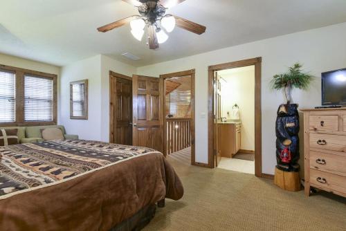 a bedroom with a bed and a ceiling fan at Sooner Settle Lodge 4 King Rooms Stonebridge in Reeds Spring