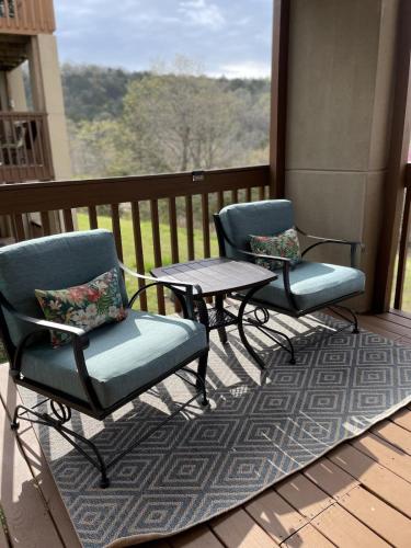 two chairs and a table on a balcony with a view at Libby's Perch No Stairs Outdoor Pool in Branson