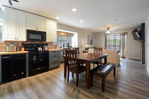 a kitchen with a wooden table and a dining room at Libby's Perch No Stairs Outdoor Pool in Branson